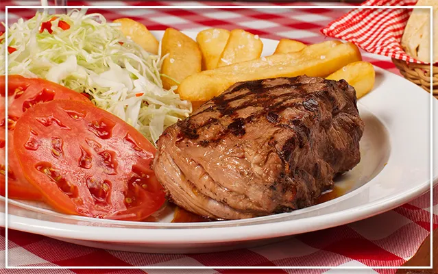 Imagen del clásico lomito con ensalada, frijoles y papas fritas de Los Anonos