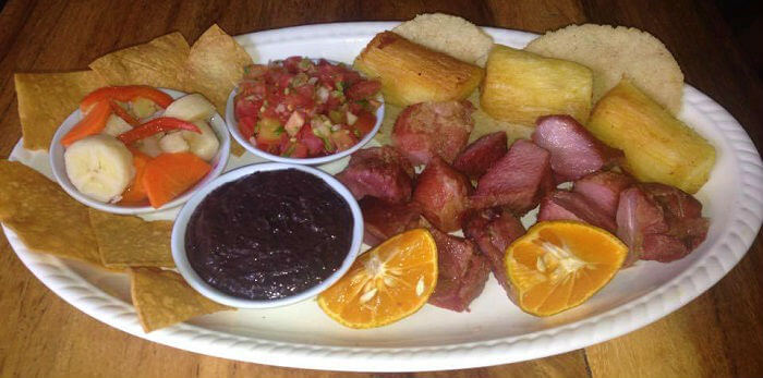 Foto de un plato con chicharrones, frijolitos y yuca